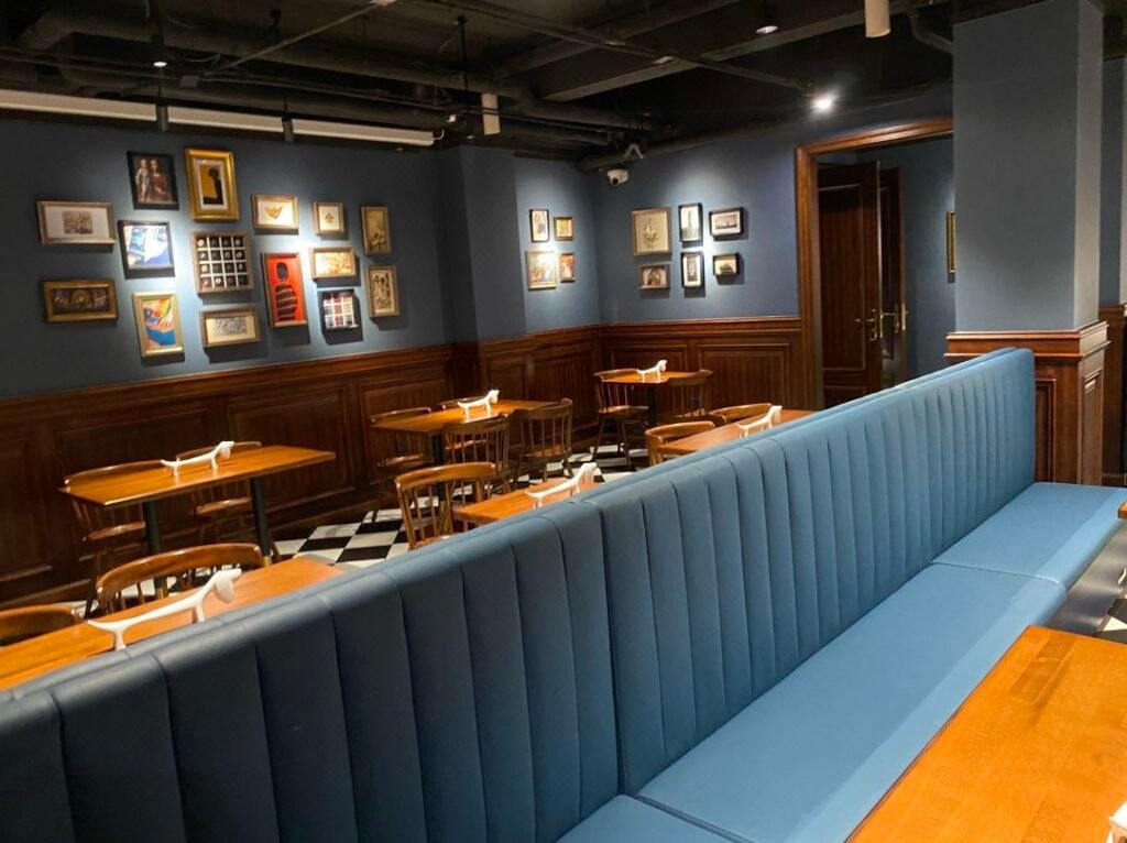 Stackable restaurant dining chairs arranged beside dining tables with additional chairs stored in a neat stack