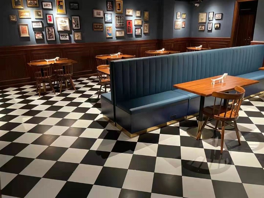 Commercial restaurant dining tables with wood finish tops and metal bases arranged in a modern dining area